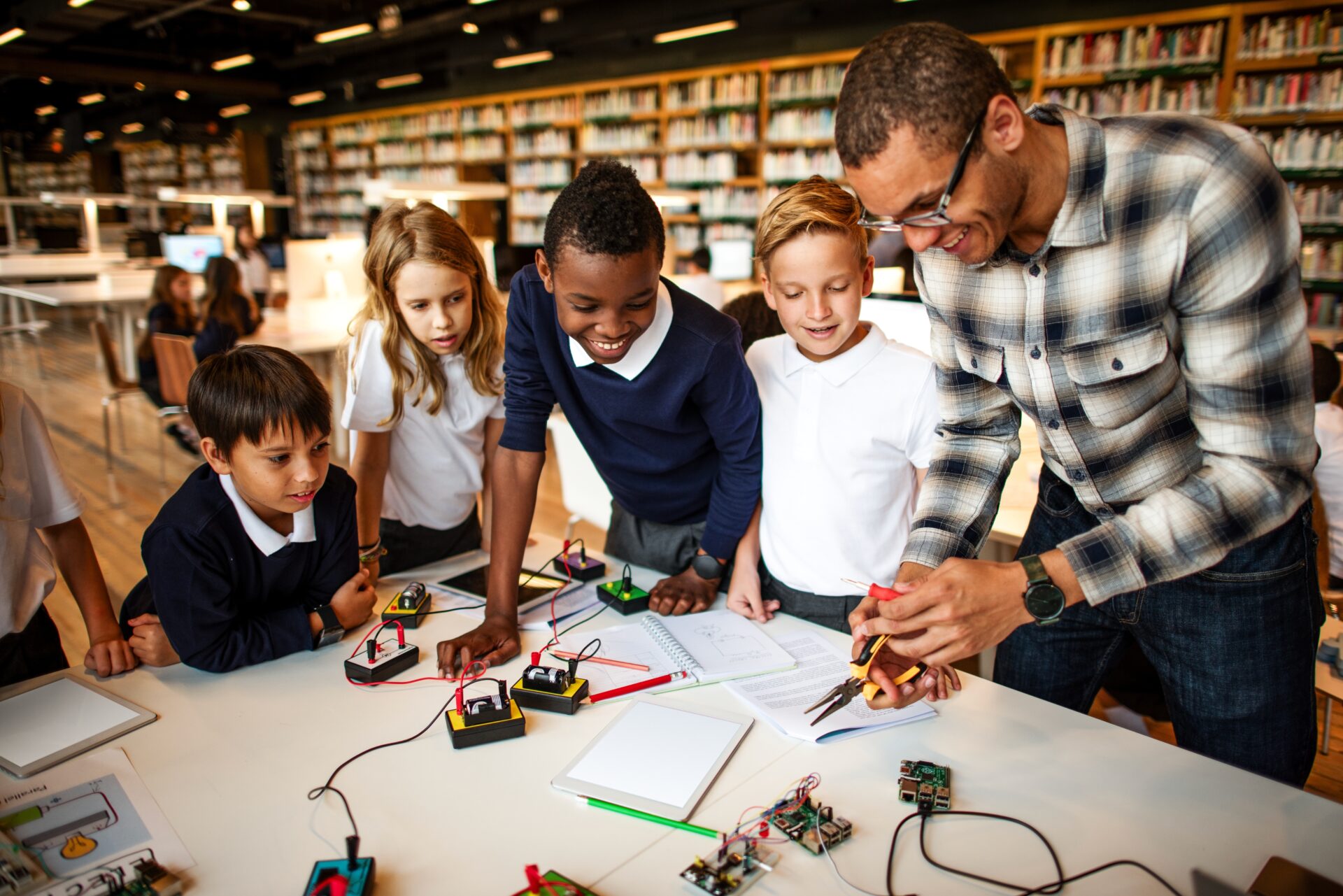 A group of students watch a teacher during a science experiment involving electricity