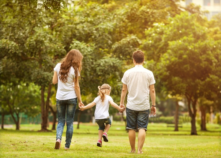 a happy family walks hand in hand while strolling in a park in Bangkok