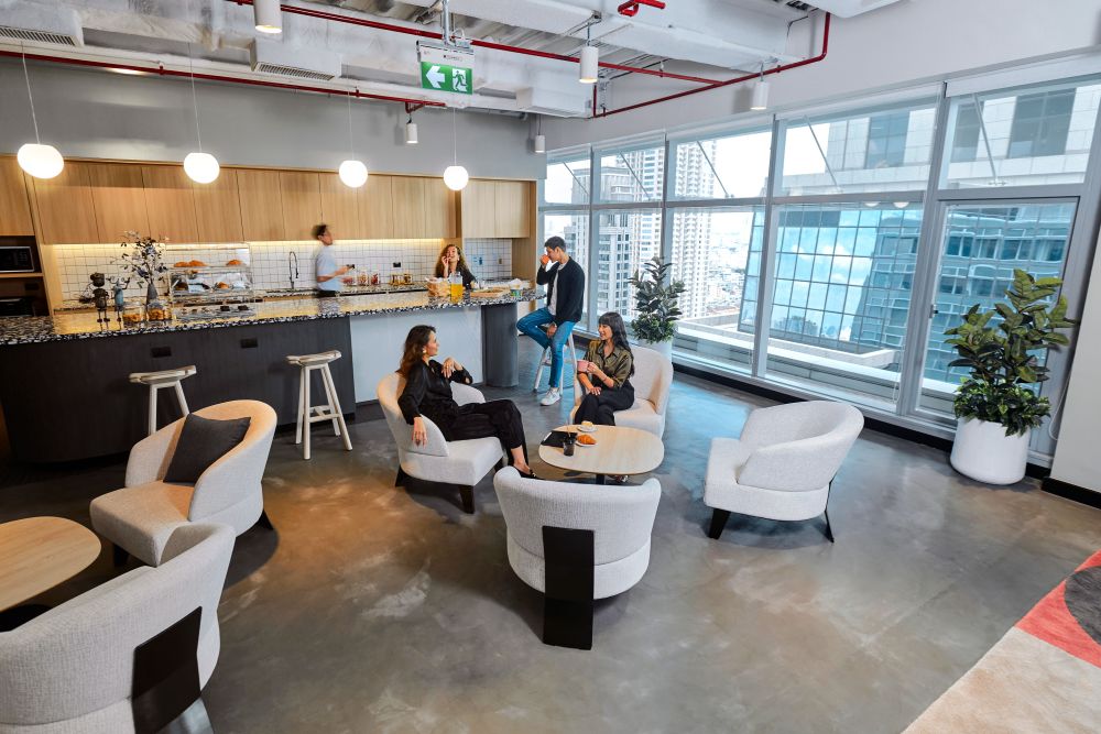 A group of people hิanging out in a lively coworking space in Bangkok.